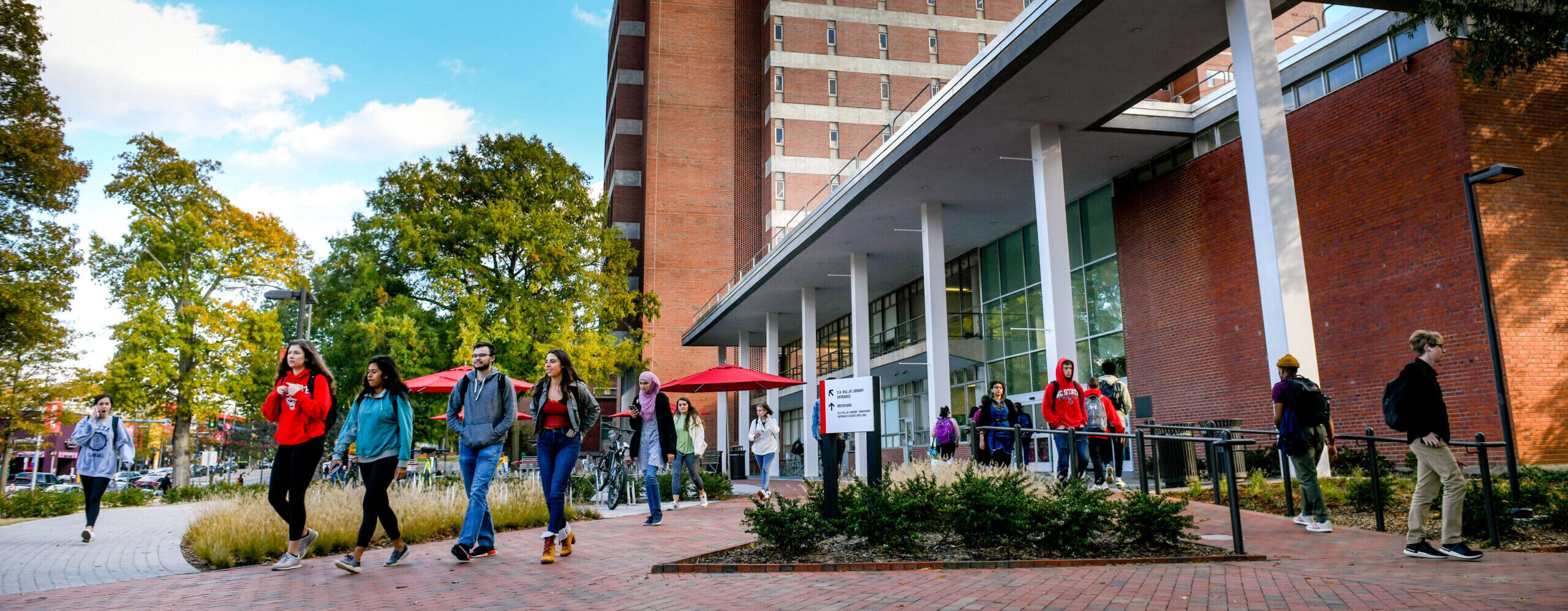 Students walk in front of DH Hill Jr. Library